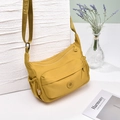 Dettaglio borsa a tracolla in nylon giallo impermeabile con tasche e tracolla larga - Giallo