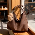 Brown frosted hobo shoulder bag with a cute plush dog pendant in a warm cafe setting - With Charm / Brown