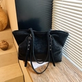 Classic black leather tote bag with long straps shown in a minimalist home setting - Black