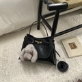 Detail of black leather bucket bag with gold hardware lock and grey plush bunny charm - Black Oil Wax Leather With Charm