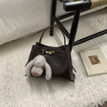 Detail of dark brown leather bucket bag with golden lock and plush rabbit pendant - Coffee Oil Wax Leather With Charm