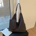Detail einer großen braunen Wildlederimitat-Tasche mit passendem kleinen Beutel im Licht - Braun
