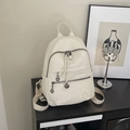 Detail eines cremeweißen Lederrucksacks mit Reißverschlusstaschen und Logo-Prägung - Weiß