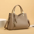 Close-up of brown lychee grain faux leather bucket bag with golden charms and hardware - Khaki