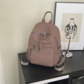 Detail des Lederrucksacks mit Litschi-Struktur, Reißverschlusstaschen und Metallanhänger - Rosa