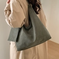 Détail d'un grand sac cabas vert foncé avec pochette assortie porté à l'épaule - Vert