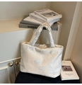 Detailed view of cream embroidered satin handbag with elegant floral patterns and soft texture - White