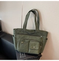 Dettaglio della borsa tote in velluto a coste verde scuro con tasche e anello metallico - Verde