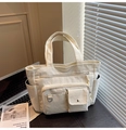 Dettaglio della borsa tote in velluto a coste crema con tasche multiple e texture - Bianco