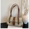 Dettaglio borsa a spalla vintage in tela kaki con rivetti metallici e cinturini in pelle - Cachi