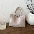 Bolso tote de ante beige con logo en mesa de madera para el viaje diario informal - Caqui