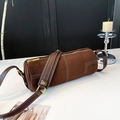 Detailed view of brown frosted cylinder bag with contrast white stitching and gold metal hardware - Coffee Solid