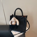 Schicke schwarze Handtasche aus Leder mit runden Griffen und Plüsch-Hasenanhänger - Mit Anhänger / Schwarz