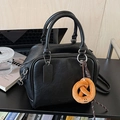 Borsa bowling vintage nera con texture in pelle e ciondolo a forma di pretzel giallo - Con Ciondolo / Nero