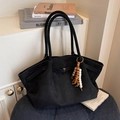 Vintage zwarte matte shopper met kralenhanger geplaatst op een blauwe stoel - Zwart