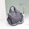 Detail der wasserfesten Nylon-Handtasche mit gewebtem Gurt und praktischer Seitentasche - Hellviolett