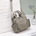 Detail der graugrünen Nylon-Handtasche mit breitem Buchstabengurt und vorderer Reißverschlusstasche - Khaki