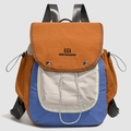 Detail eines mehrfarbigen Nylonrucksacks mit Kordelzug-Seitentaschen und Bestickung - Warmes Orange