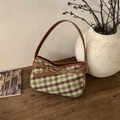 Detalle del bolso de hombro a cuadros verde y marrón sobre mesa de madera vintage - Cuadros Verde Marrón