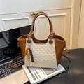 Sac seau en cuir marron et tissage beige avec gland perlé sur un livre de design - Blanc