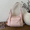 Detail der hellrosa Nylon-Halbmond-Umhängetasche mit Klapptasche auf Holzoberfläche - Hellrosa