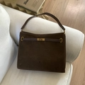 Dunkelbraune matte Wildleder-Einkaufstasche mit goldenem Drehverschluss auf Sofa - Braun