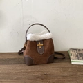 Detailaufnahme der braunen Wildledertasche mit weißem Kunstpelz und goldenem Verschluss - Braun