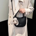 Black pebbled leather crescent handbag with MUCOOU branding and adjustable crossbody strap - Black with Pendant