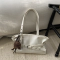 Detalle del bolso tote de cuero sintético blanco crema con pliegues laterales y hebillas - Blanco con colgante