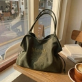 Olive green suede tote bag with yellow daisy embroidery in a cozy cafe setting - Green