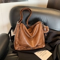 Grand sac cabas marron avec charme en peluche et sangle sur un siège en cuir - Marron avec pendentif