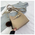 Detailed close-up of beige lychee grain handbag with silver turn-lock and fuzzy charm - Sand (With Pendant)