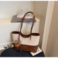 Detail van een grote color-block draagtas met een schattige teddybeerhanger op een textuur - Met Hanger / Broken Wit