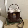 Deep brown suede bucket bag featuring white faux fur trim and gold twist-lock closure - Brown