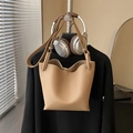 Light camel lychee leather bucket bag with minimalist strap design hanging on a hanger - Khaki (No Pendant)