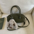 Detail einer dunkelgrünen zylindrischen Handtasche mit Wildledertextur und Kaninchenanhänger - Mit Plüsch-Hasen-Anhänger / Grün