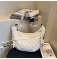 Detail of white quilted crescent bag with adjustable wide strap and woven zipper pull - White