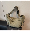 Detailed shot of army green quilted crossbody bag with buckle and woven zipper pull - Green