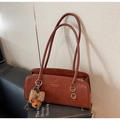 Detalle de bolso vintage de cuero marrón con logo dorado y colgante de oso peluche - Con Colgante / Marrón