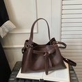 Detalle del bolso tote de cuero marrón oscuro con nudo decorativo y asa ajustable - Marrón