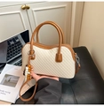 Detail of cream and brown boston bag with woven texture and decorative beads - White