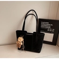 Dettaglio della borsa tote nera con trama opaca e un simpatico ciondolo a forma di orso - Senza Ciondolo / Nero