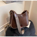 Dettaglio borsa a secchiello vintage marrone con tracolla jacquard e fibbie dorate - Marrone