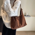 Brown faux suede tote bag with wide shoulder strap shown on model in minimalist setting - Red Brown