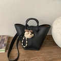 Close-up of black lychee texture tote bag with plush bear charm and beaded handle - With Charm / Black