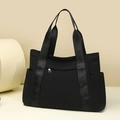 Detalle de bolso tote grande de nailon negro con cremallera metálica y bolsillos laterales - Negro