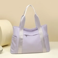 Vista detallada del bolso tote de nailon lila con correas grises y bolsillos laterales - Lavanda