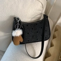 Black polka dot crescent shoulder bag with a unique plush glove charm accessory - Black