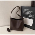 Detailaufnahme der dunkelbraunen Eimer-Tasche aus Leder mit verstellbarer Silberschnalle - Braun