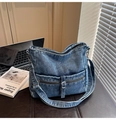 Vue détaillée d'un sac bandoulière en denim bleu délavé avec fermetures et boucles - Bleu clair